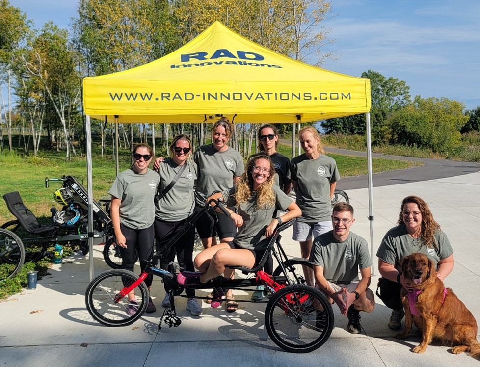 A team of participants poses in front of a tent.