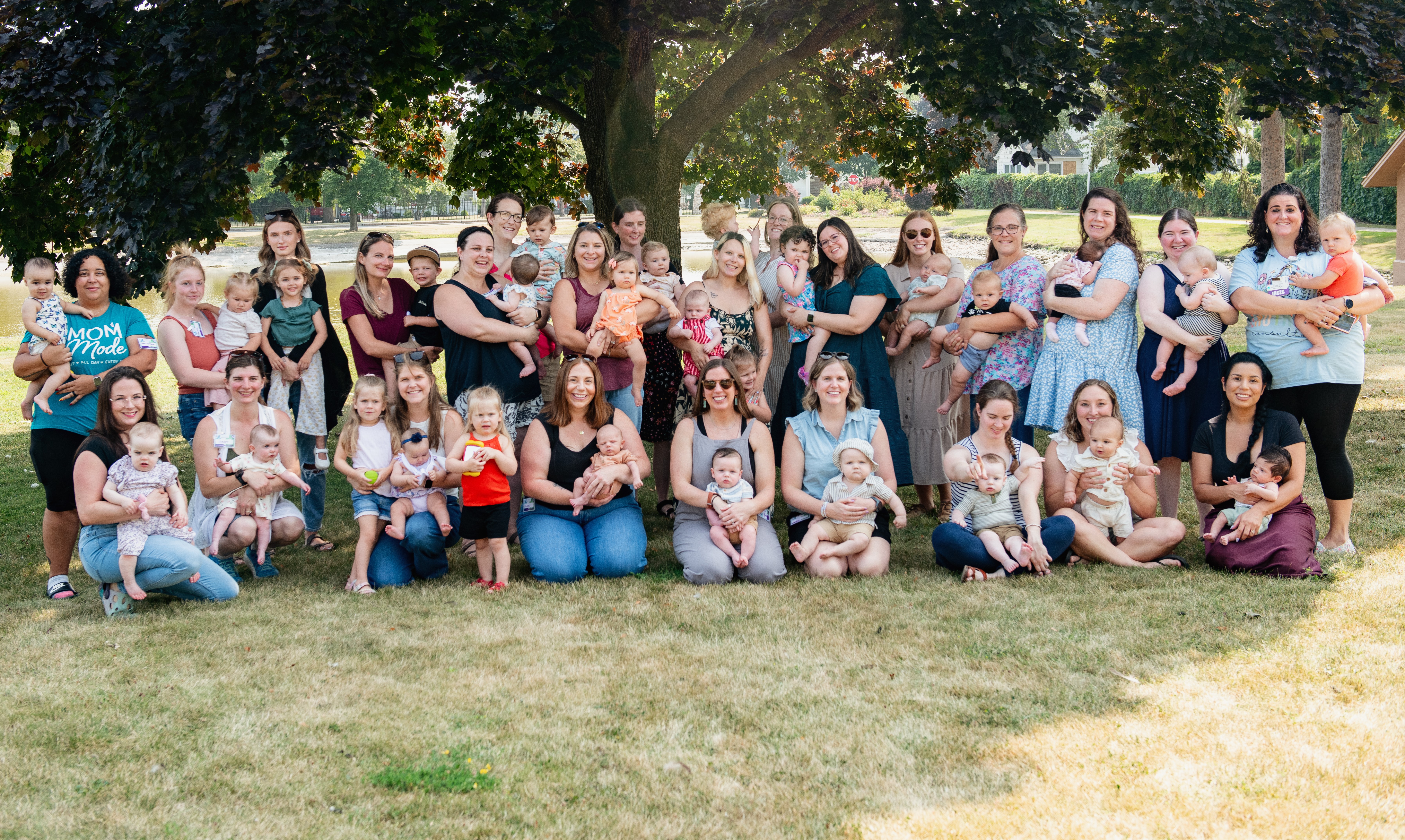 A group of women and their children pose and smile for the camera.
