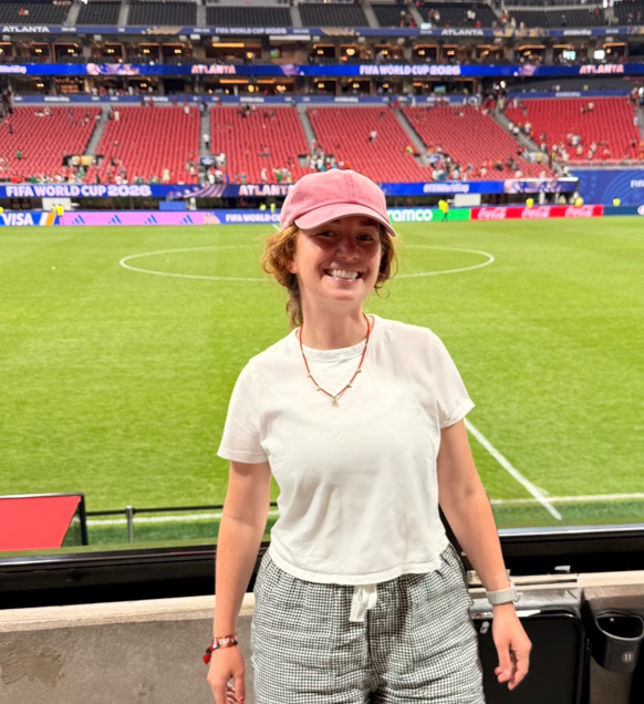 Caroline George, MD in stands with soccer field in background