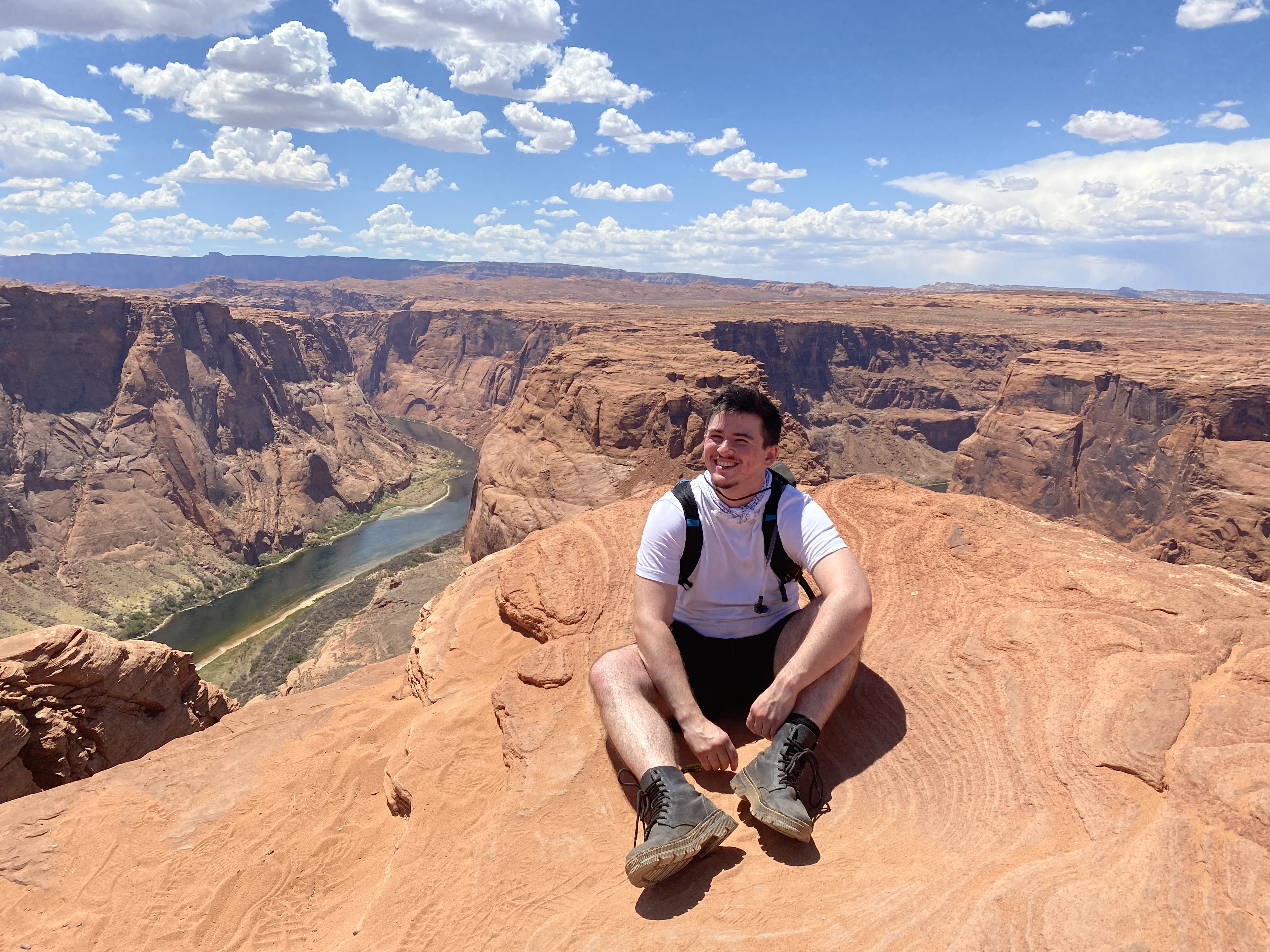 Sebastian Taylor, MD sitting on the rim of Grand Canyon