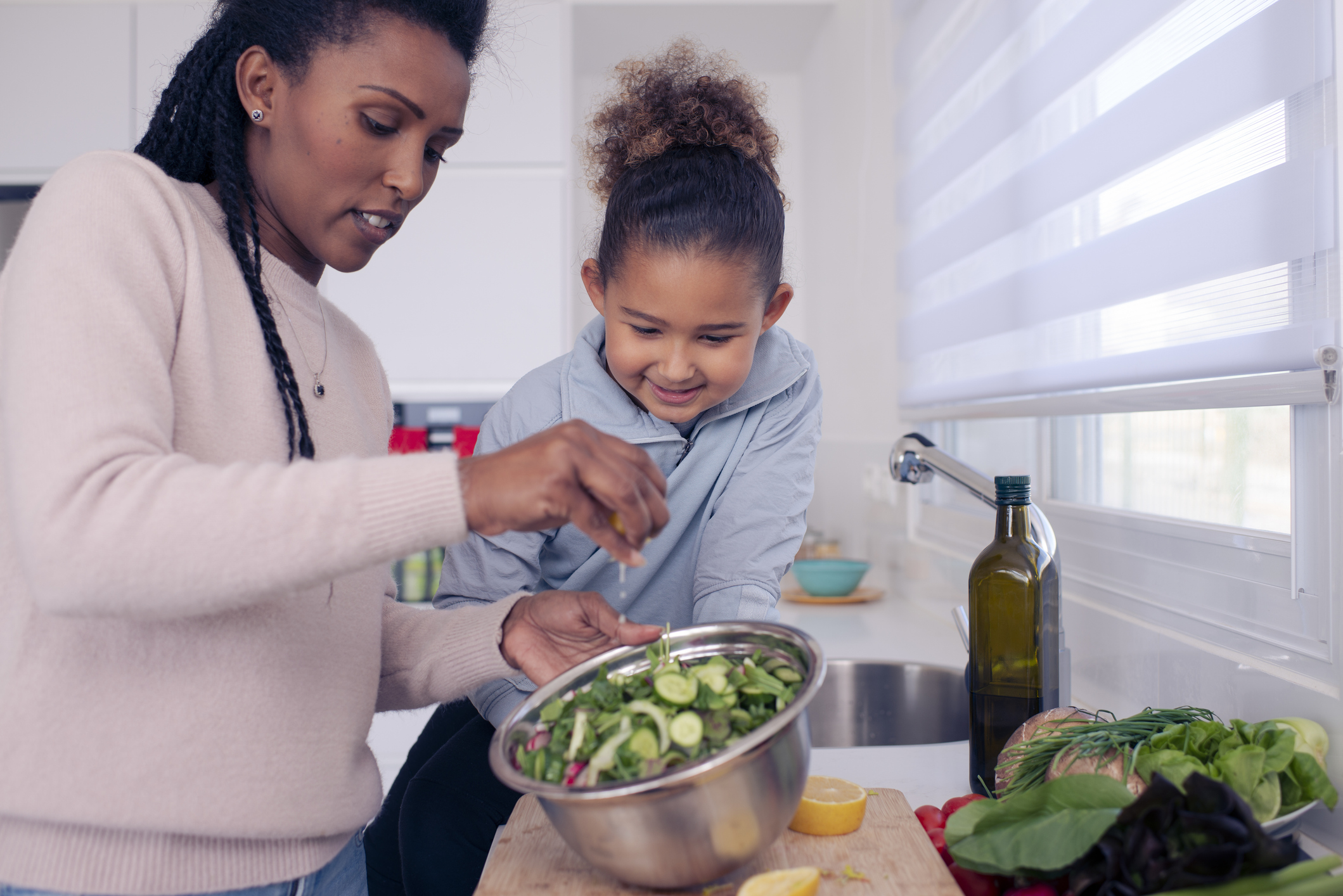 an adult and child cooking together 
