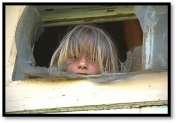 Child looking through broken window