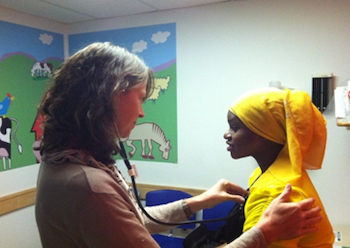 Pediatrician checking young girl's heart rate.