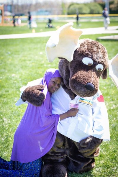Monty the Moose mascot hugging child