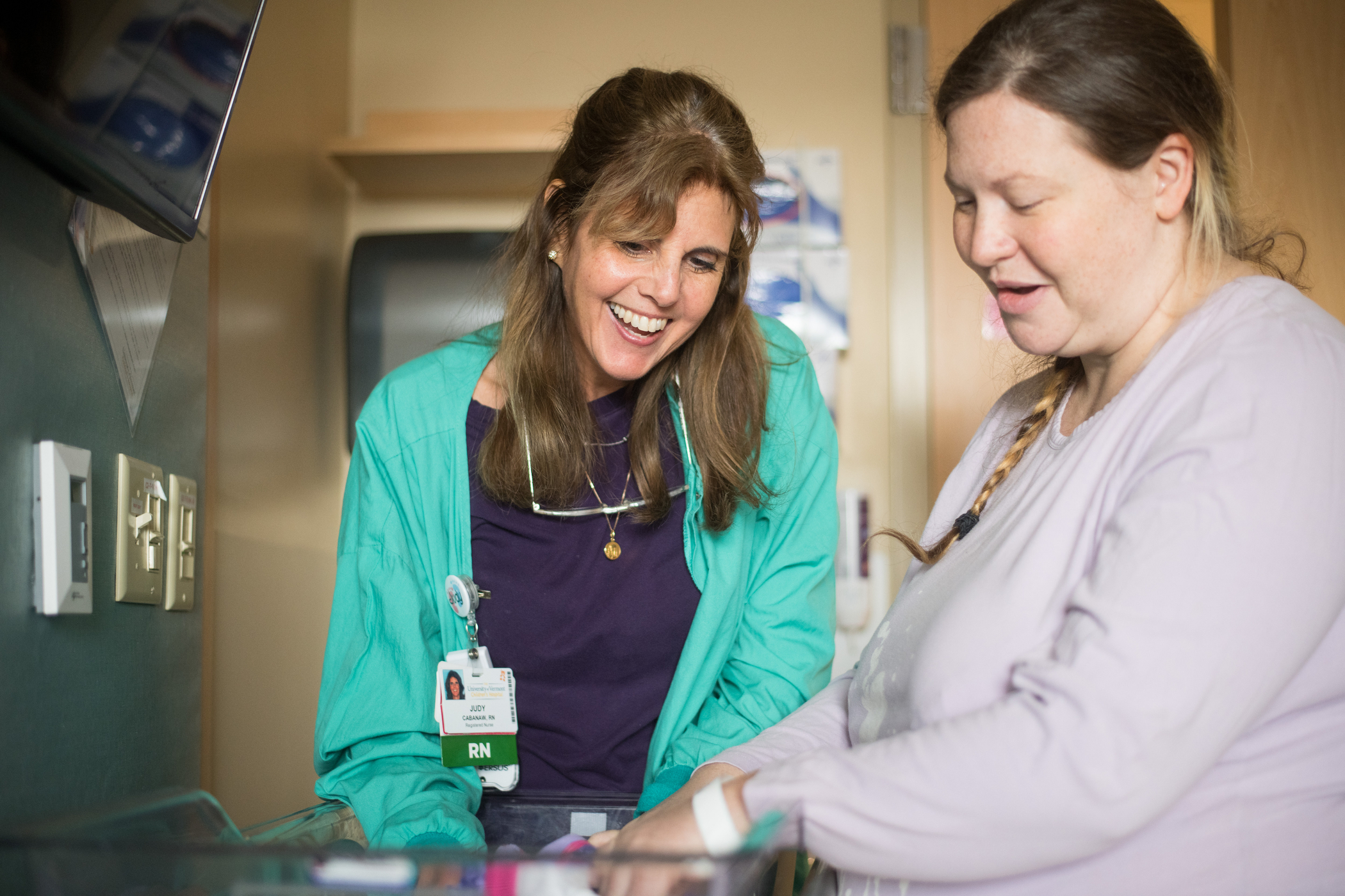 a nurse and a mother looking at a newborn baby