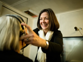 Audiologist Deborah Rooney puts headphones on a patient.