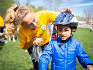 UVM Children's Hospital staff helps a young boy with his bike helmet.