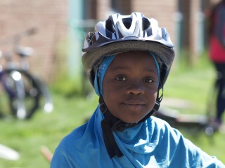 Child wearing a bike helmet smiles.