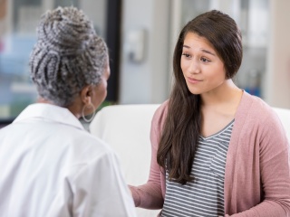 A young female meets a with medical provider.