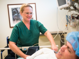 Porter Medical Center staff talks to a patient in a bed before urology surgery.