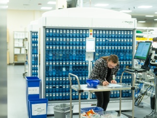 A pharmacist writes a note in the pharmacy. 
