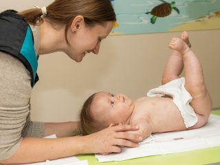 A mother leans over her baby who is getting an Ultrasound.