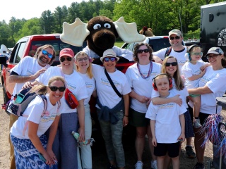 Patient and family advisors pose with Monty the moose at a memorial day parade.