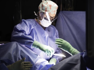 A surgeon conducts a hysterectomy on a patient.