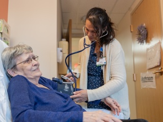 A medical provider takes a resident's blood pressure.