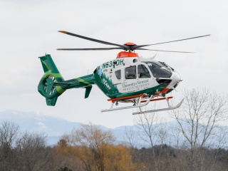 A UVM Health Network helicopter hovers in the air.