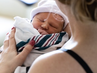 A mother holds her newborn baby.