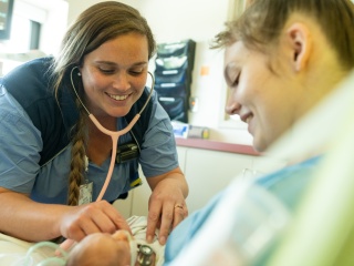 A nurse performs a check on a newborn baby.