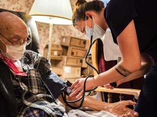 A nurse checks the blood pressure of a patient.
