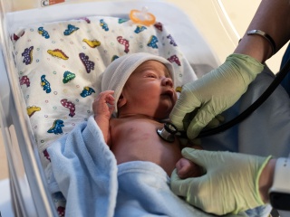 A newborn baby at the Alice T. Miner Women & Children's Center lies in a bassinet. 