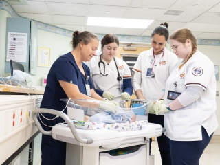 Champlain Valley Physicians Hospital labor and delivery nurse works with Clinton Community College students on taking care of a newborn baby.