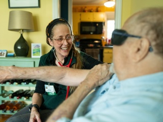 A nurse smiles and talks to a patient. 
