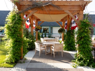 Outdoor courtyard and seating area under a pergola at Woodridge Rehabilitation. 