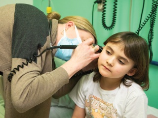 A child has an ear check by a pediatric provider at the UVM Medical Center Children's Hospital.