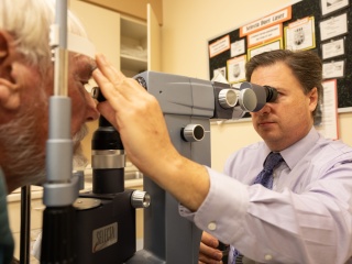 An adult patient receives an eye exam from an ophthalmologist at UVM Medical Center.