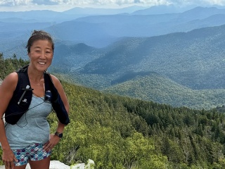 Amanda Gibbs trail running at the summit of a mountain.