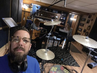 Michael Dufort plays drums in a recording studio.