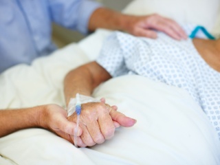 Person holding patients hand in the hospital.