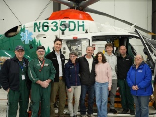 Stahl Family and UVM Health Network staff pose in front of hospital helicopter.