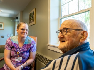A medical provider talks to a resident.