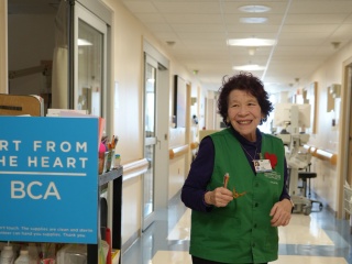UVM Medical Center volunteer Lori wheels an art cart to patient rooms.