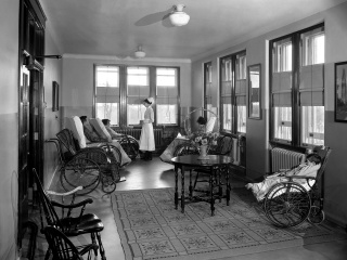 Historical photo of the sun parlor with patients in wheel chairs at Champlain Valley Physicians Hospital.