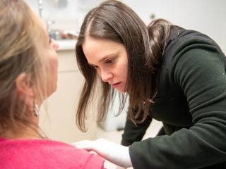 A dermatologist examines a patient's skin in an exam room at Central Vermont Medical Center..