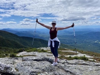 Mariah Mitchell stands on the summit of a mountain she hiked.
