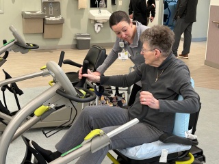 A rehab therapist assists a patient.