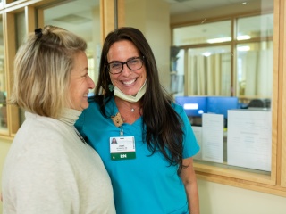 Two medical providers smile at each other.