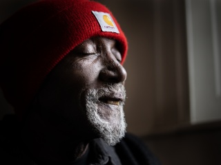 Portrait of patient Darrell Fields wearing a red hat.