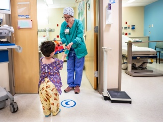A Child Life Specialist at Golisano Children's Hospital talks with a pediatric patient.