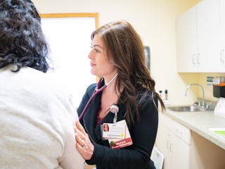 A medical provider listens to a patient breathing.