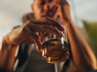 Stock photo of adult holding a glass of alcohol.