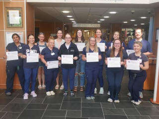A group of nurse residency grads poses with their certificates.