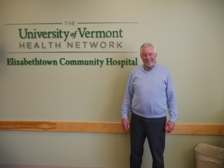 Thomas Dwyer poses in front of a sign.