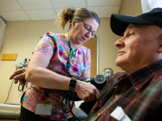 A primary care provider at Middlebury Primary Care at Porter Medical Center checks a patient's blood pressure.