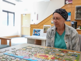 A patient sits and does a puzzle.