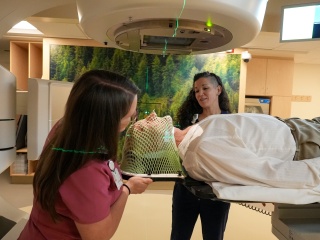 Two medical professionals help a patient with a scan.