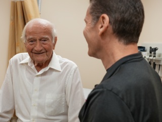 A medical professional smiles on at a patient.